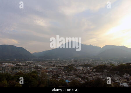 The landscape of Beppu in Oita and golf range as seen from a hill in sunset. Including the steam! Stock Photo