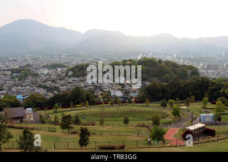 The landscape of Beppu in Oita and golf range as seen from a hill in sunset. Including the steam! Stock Photo