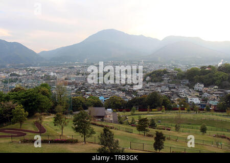 The landscape of Beppu in Oita and golf range as seen from a hill in sunset. Including the steam! Stock Photo