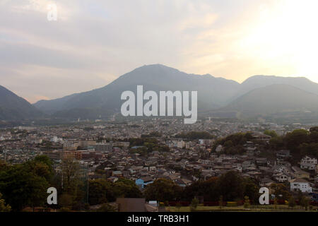 The landscape of Beppu in Oita and golf range as seen from a hill in sunset. Including the steam! Stock Photo