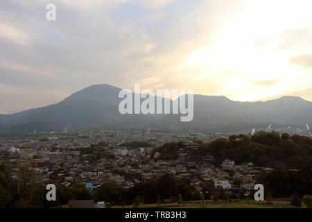 The landscape of Beppu in Oita and golf range as seen from a hill in sunset. Including the steam! Stock Photo