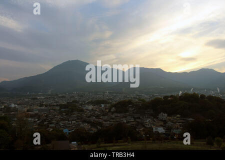 The landscape of Beppu in Oita and golf range as seen from a hill in sunset. Including the steam! Stock Photo