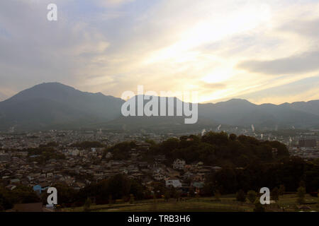 The landscape of Beppu in Oita and golf range as seen from a hill in sunset. Including the steam! Stock Photo