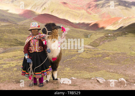 Peru indigenous Quechua people - Elderly Quechua woman with her llama poses for a photo at the Palccoyo Mountain in Peru, South America. Stock Photo