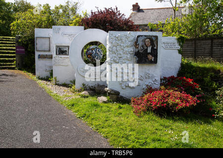 A  stone display painted white and adorned with colourful pictures and quotes to commemorate John Wesley and Methodism at Gwennap Pit in Cornwall Stock Photo