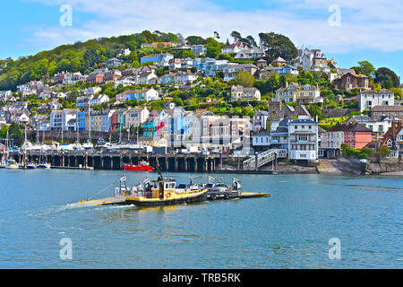 The Dartmouth Lower Ferry approaches Kingswear after crossing the tidal river Dart from Dartmouth. The pontoon ferry is pushed/pulled by a tug boat. Stock Photo