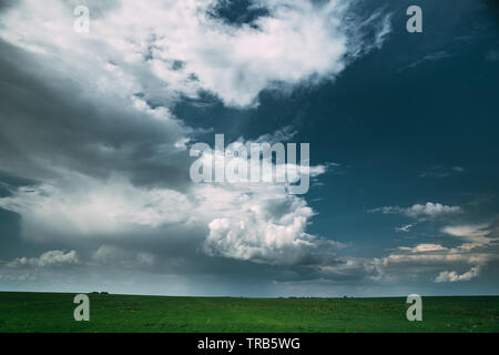 Countryside Rural Field Meadow Landscape In Summer Rainy Day. Scenic Dramatic Sky With Rain Clouds On Horizon. Agricultural And Weather Forecast Conce Stock Photo