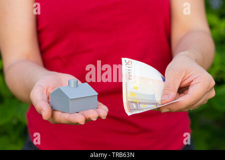 3d printed house and euro in female hands, bank loan for new housing project Stock Photo