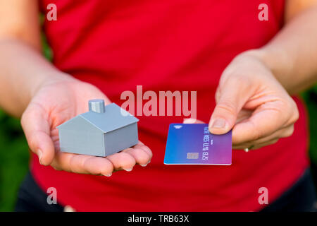 3d printed house and credit card in female hands, new investments in the housing business Stock Photo