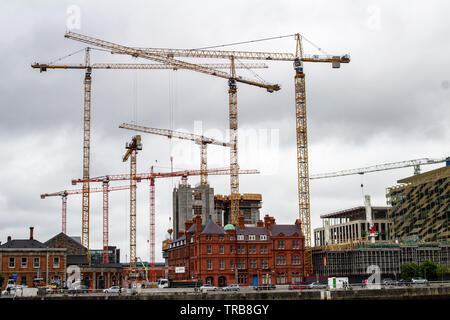 Construction Cranes over one of the many building sites in the docklands area of Dublin, Ireland.. Stock Photo