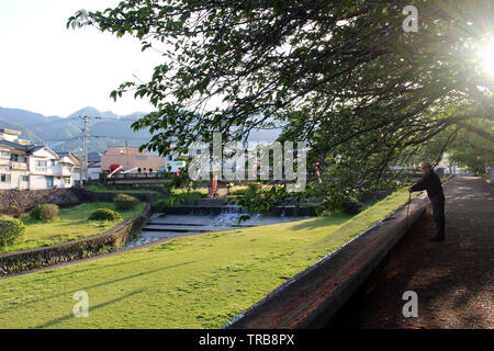 An old man with cane enjoying walk at one park in Beppu. Taken in Oita ...
