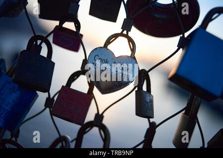Beautiful close up of love locks hanging on a bridge in early evening sunset Stock Photo