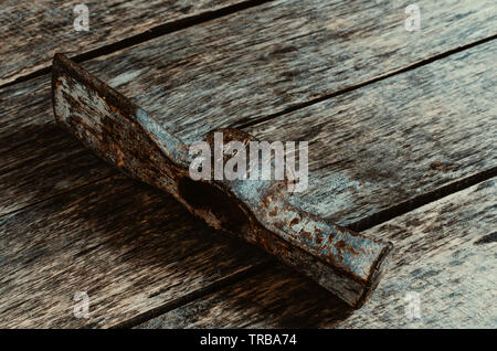 Old rusty hammer on wooden background. Stock Photo