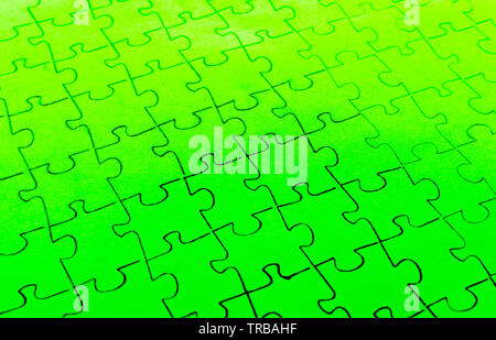 Assembled puzzle on a bright green background. Stock Photo