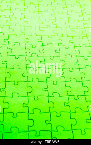 Assembled puzzle on a bright green background. Stock Photo