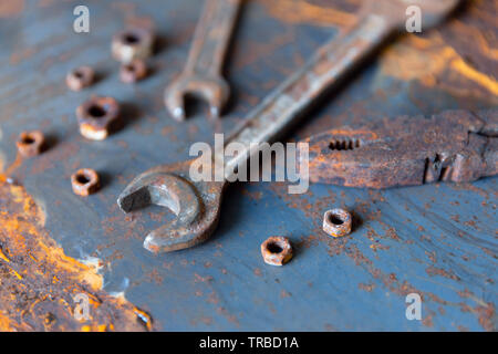 Old rusty wrench over battered metal table rough style. Wrenches top view for construction, industrial, electrician concept design Stock Photo
