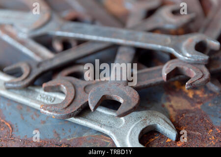Old rusty wrench over battered metal table rough style. Wrenches top view for construction, industrial, electrician concept design Stock Photo