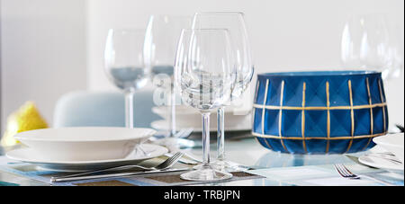 Horizontal image table setting with empty wine glasses, white plates bowls and flatware served on table. Close up of tableware, dishes, nobody Stock Photo