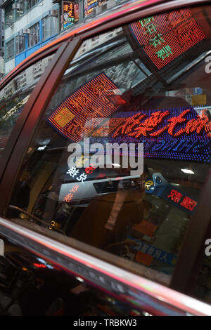 colorful neon reflected in car window in Hong Kong Stock Photo