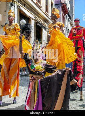 Colourfully dressed stilt walkers perform in one of the old streets in the Old Town of Havana, or Havana Vieja, Cuba, Caribbean Stock Photo