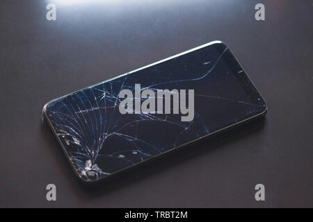 Smartphone with broken touchscreen screen on black table desktop Stock Photo