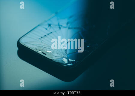 Smartphone with broken touch-screen screen on black table desktop Stock Photo