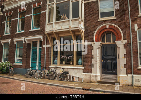 Brick building in an unusual design and bicycles on street of Dordrecht. City with important and historic port in Netherlands. Stock Photo