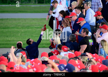 Donald Trump Jr. returns a signed red MAGA hat to a fan during a campaign rally with US President Donald J. Trump MAGA rally in Montoursville, PA Stock Photo