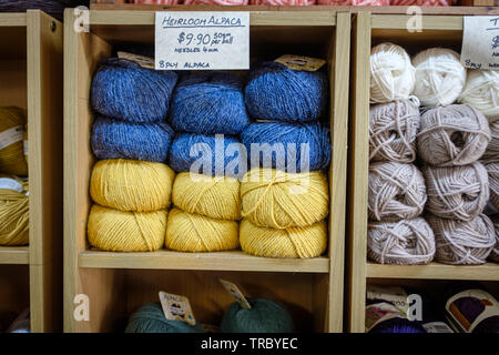 Colourful balls of Heirloom Alpaca wool piled up on shelf in craft shop Stock Photo
