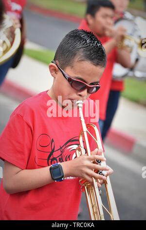 Hispanic kids who are members of California schools marching bands with instruments at Santa Maria parade Stock Photo