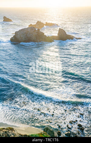 The setting sun creates shadows behind sea stacks along a beautiful coastline, Big Sur, California, USA. Stock Photo