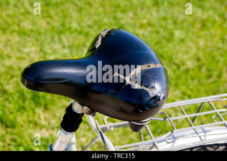 Broken and damaged bike saddle due to heat and usage. Foam coming outside and not usable anymore. Stock Photo