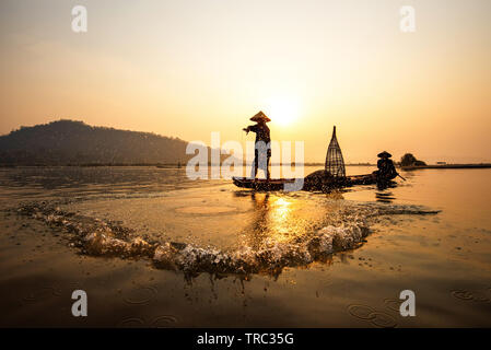 Asia fisherman net using on wooden boat casting net sunset or sunrise in  the Mekong river - Silhouette fisherman boat with mountain background life  pe Stock Photo - Alamy