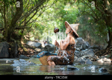 Asaia old lady shower on river stream nature in countryside of living life senior woman farmer rural people / Natural Spa Stock Photo