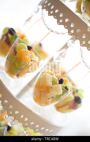 Glass fruit cups set on a tiered cake display,  assortment of sweets and cakes at a candy buffet, tasty assortment of fruit, healthy option dessert Stock Photo