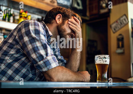 Sad man sitting in beer bar Stock Photo