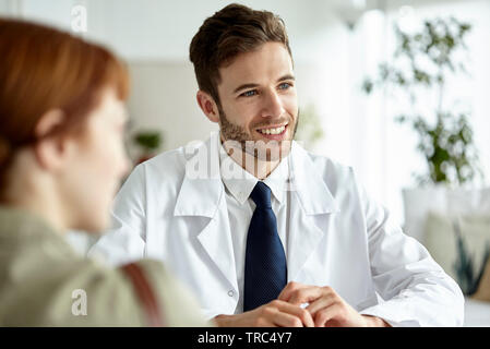 Smiling doctor talking with patient Stock Photo