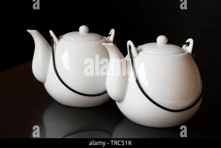 White kettles or tea pots on black background Stock Photo