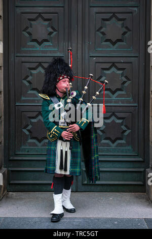 Scottish piper playing bagpipes on Royal Mile outside Edinburgh High Court in Edinburgh Old Town, Scotland ,UK Stock Photo