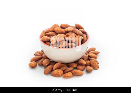 Heap almonds in cup on white background Stock Photo