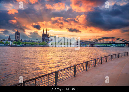 Cologne, Germany. Cityscape image of Cologne, Germany with Cologne Cathedral and Hohenzollern Bridge during dramatic sunset. Stock Photo