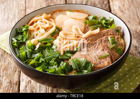 Lanzhou beef noodle soup is a type of Chinese ramen noodle soup with beef slices served on the top closeup in a bowl on the table. horizontal Stock Photo