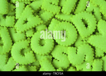 Heap of bright green alphabet shaped biscuits spelling the word GOOD Stock Photo