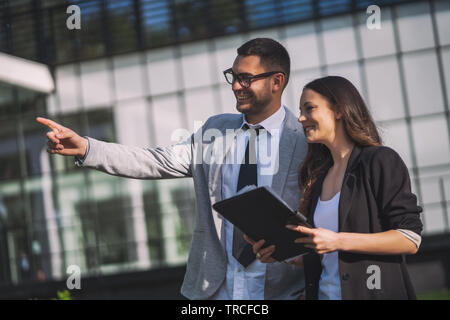Business colleagues are talking outside the company building. Stock Photo