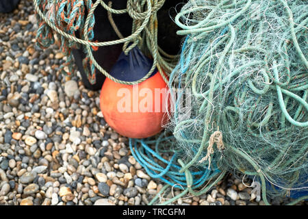 Green nylon plastic fishing nets and rope on a beach Stock Photo