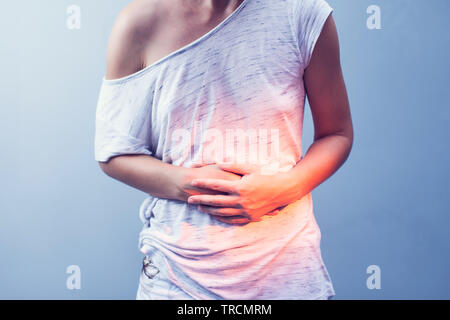 Woman with pain is holding her aching belly - isolated on white background Stock Photo