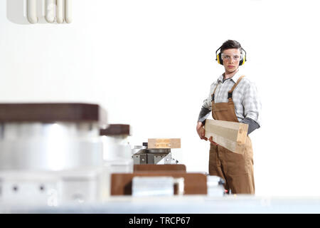 carpenter man works with wooden planks in the joinery, with computer numerical control center, cnc machine,  isolated on a white background Stock Photo