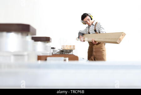 carpenter man works with wooden planks in the joinery, with computer numerical control center, cnc machine,  isolated on a white background Stock Photo