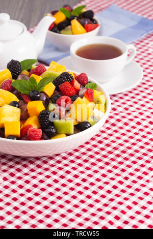 A Table Set for Breakfast with Fresh Fruit Salad on a Red Plaid Table Cloth Stock Photo