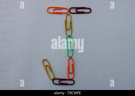 Letter J made with colorful paper clips on white background Stock Photo